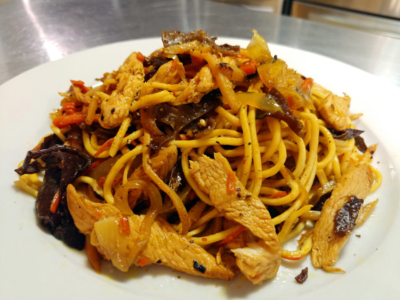 Plate of Lo Mein with Chicken, noodles tossed with chicken, wood ear mushroom, carrot and onion