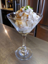 Chicken Salad Chicken Salad served in a martini glass with creamy dressing and a chive garnish on a metal counter.