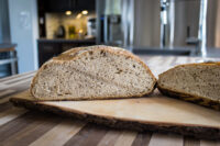 Sliced Czech Rye Bread loaf on a wooden board, showing its dense crumb and dark crust.
