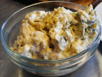 Glass bowl of Artichoke Spinach Dip with creamy texture and visible spinach pieces