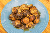 Bobalky with Poppyseeds and Honey piled on a textured blue plate, glistening with syrup.