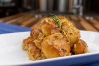 Plate of Bobalky with Sauerkraut, golden bun pieces topped with shredded sauerkraut and a rosemary sprig.