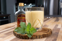 Czech Egg Liqueur – Czech Eggnog in a cut-glass tumbler beside a Božkov rum bottle and mint.
