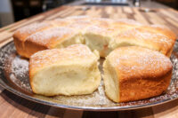 Golden buchty – Czech sweet buns – pulled apart on a metal plate, dusted with powdered sugar.
