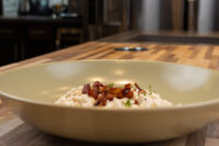 Bowl of Halušky with Bryndza Cheese Substitution topped with crispy bacon bits and herbs.