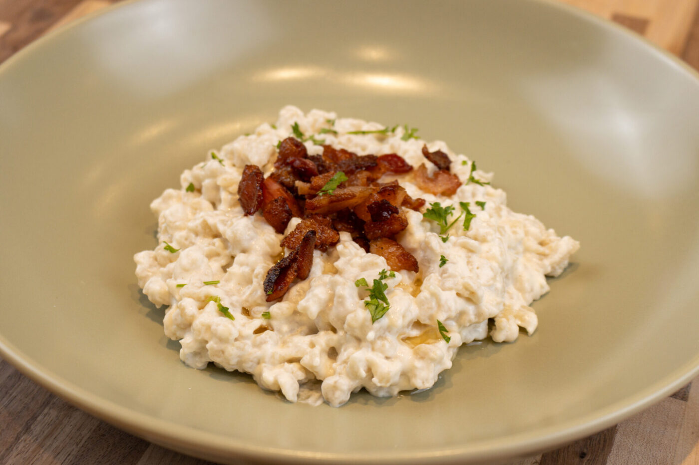 Bowl of Halušky with Bryndza Cheese Substitution topped with crispy bacon and chopped herbs