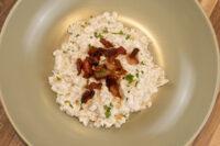 Bowl of Halušky with Bryndza Cheese Substitution topped with crispy bacon and herbs