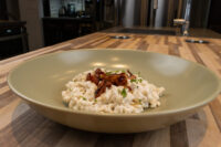 Halušky with Bryndza Cheese Substitution in a sage-green bowl, topped with crispy bits and herbs.