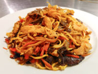 A heaping plate of Lo Mein with Chicken, noodles tossed with shredded chicken, carrots, onions, and mushrooms.