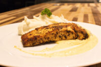 Seared Salmon in Mustard Sauce fillet on cream sauce with piped mashed potatoes and parsley