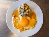 Chicken Breasts with Peach and Cheese topped with melted cheese and gravy, beside roasted herbed potatoes.