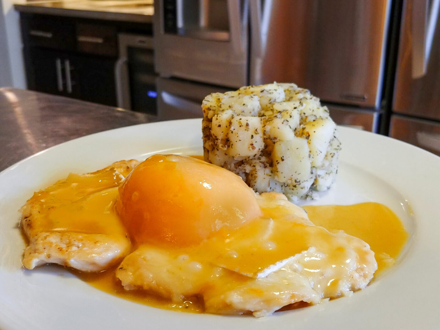 Chicken Breasts with Peach and Cheese, gravy-topped, with a peach half and herbed potato side