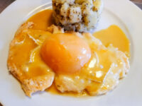 Chicken Breasts with Peach and Cheese: chicken in orange sauce topped with a peach half, beside mashed potatoes.