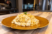 Mound of Halušky with Sauerkraut on a gold plate, topped with a sprig of parsley.