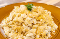 Plate of Halušky with Sauerkraut, garnished with a sprig of parsley.
