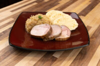 Sliced pork, sauerkraut, and dumpling slices plated for Pork-Sauerkraut-Dumpling (Vepřo-knedlo-zelo).