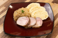 Sliced pork with sauerkraut and dumpling slices, plated as Pork-Sauerkraut-Dumpling (Vepřo-knedlo-zelo)