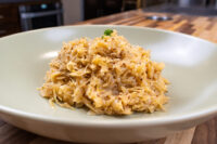 Shallow bowl of Sauerkraut (Kysane Zelí), shredded and glossy, topped with a small herb sprig.