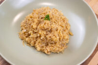 A mound of Sauerkraut (Kysane Zelí) piled on a green plate, garnished with chopped herbs.