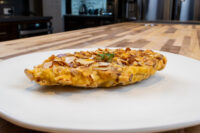 Golden Almond Chicken Schnitzel with a crisp sliced almond crust on a white plate.