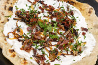 Lokše Flat Bread with Bryndza Cheese Substitute and Bacon, topped with crispy onions, bacon, and chives.