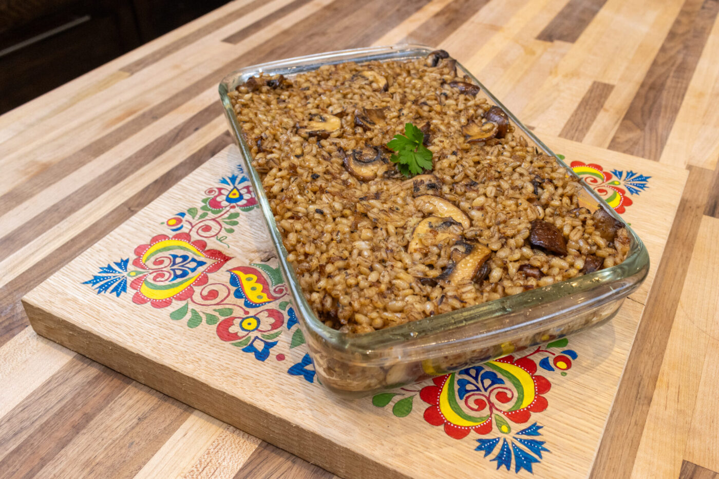 Baked Mushroom Kuba (Houbovy Kuba) with barley and mushrooms in a glass dish, garnished with parsley.