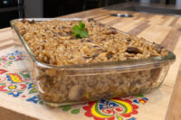 Baked Mushroom Kuba (Houbovy Kuba) in a glass dish, topped with mushroom pieces and parsley.
