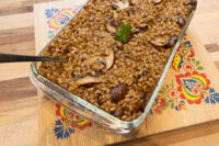 Glass dish of baked Mushroom Kuba (Houbovy Kuba) with barley, mushrooms, and parsley garnish