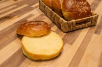 Burger Buns Sesame-seed Burger Buns, one sliced open showing soft interior, others in a woven basket.