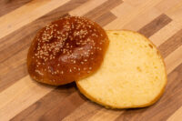 Burger Buns Sesame seed Burger Buns split in half, cut side up on a wooden board