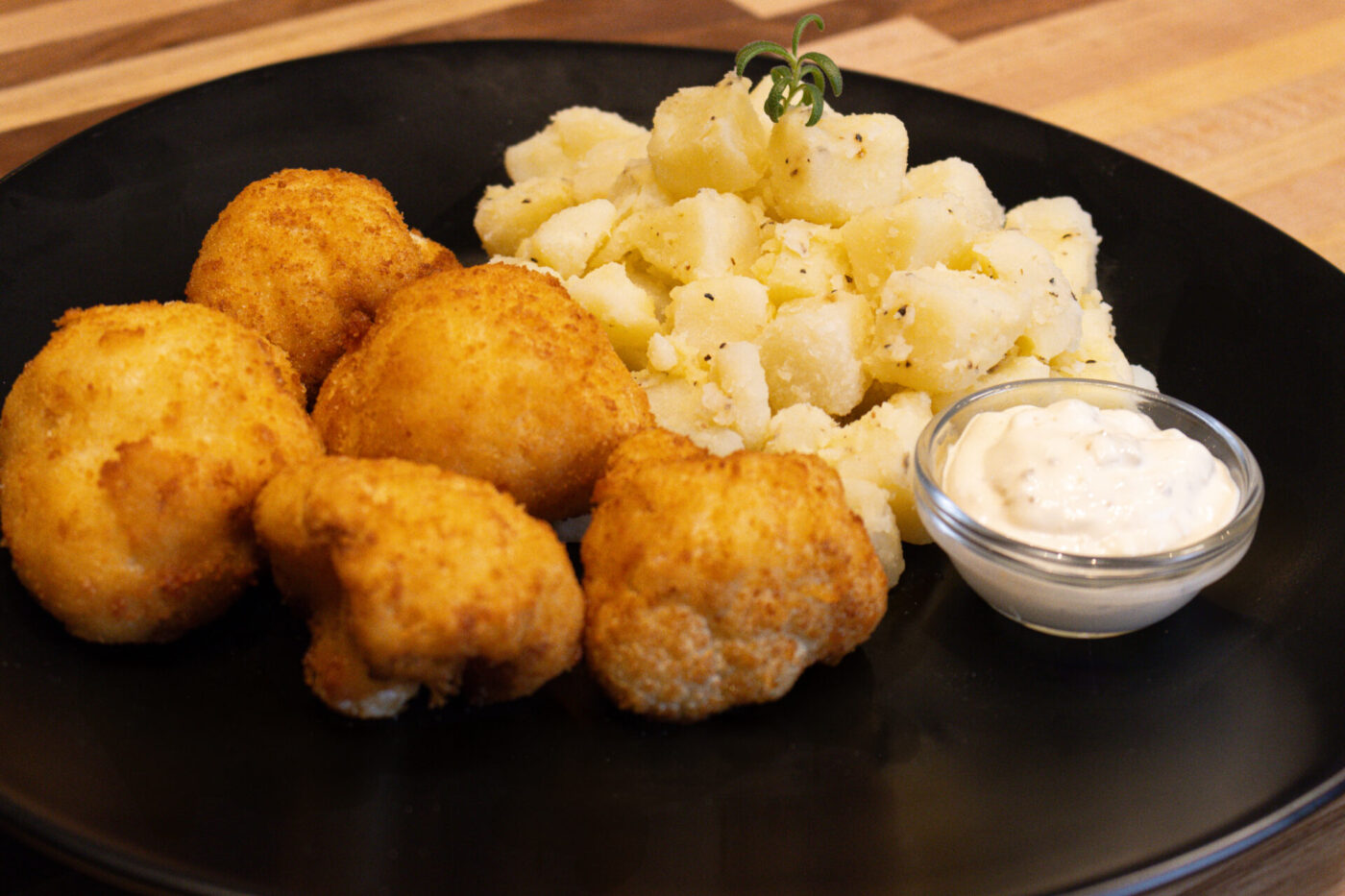 Plate of Fried Cauliflower Smažený Květák with buttered potatoes and a creamy dip.