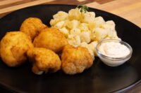 Plate of Fried Cauliflower Smažený Květák with buttered potatoes and a creamy dip.