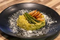 Plated Asparagus Risotto with Shrimp topped with grilled asparagus and shrimp, dusted with parmesan.