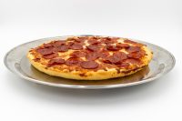60 min. Pan Pizza with pepperoni and melted cheese on a thick golden crust, served on a metal tray.