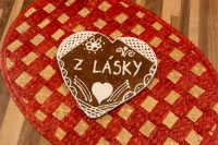 Heart-shaped Gingerbread Heart Cookie with white icing swirls and 'Z LÁSKY' text on a woven placemat.