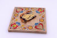 Slice of Sheet Kolach with Streusel showing crumb topping and dark berry filling on a painted board.