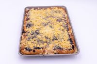 Sheet Kolach with Streusel on a metal baking sheet, golden crumb topping with dark berry filling showing through.