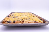 Side view of Sheet Kolach with Streusel in a metal baking sheet, streusel crumbs and dark berry filling visible.