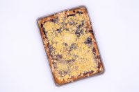 Overhead view of baked Sheet Kolach with Streusel, golden crumb topping over dark berry filling in a metal pan