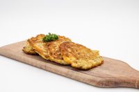 Four crispy Side Potato Pancakes Bramboráčky on a wooden board with parsley garnish.