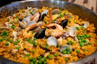 Large pan of Paella with saffron rice, shrimp, mussels, clams, and green peas